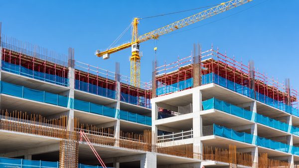 Parking structure under construction with exposed concrete decks and steel reinforcement