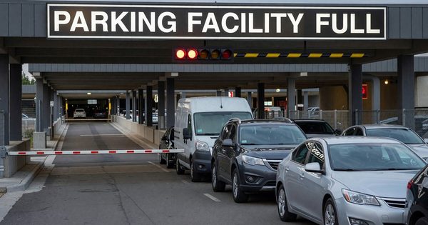 Parking facility entrance with full sign and vehicles waiting to enter