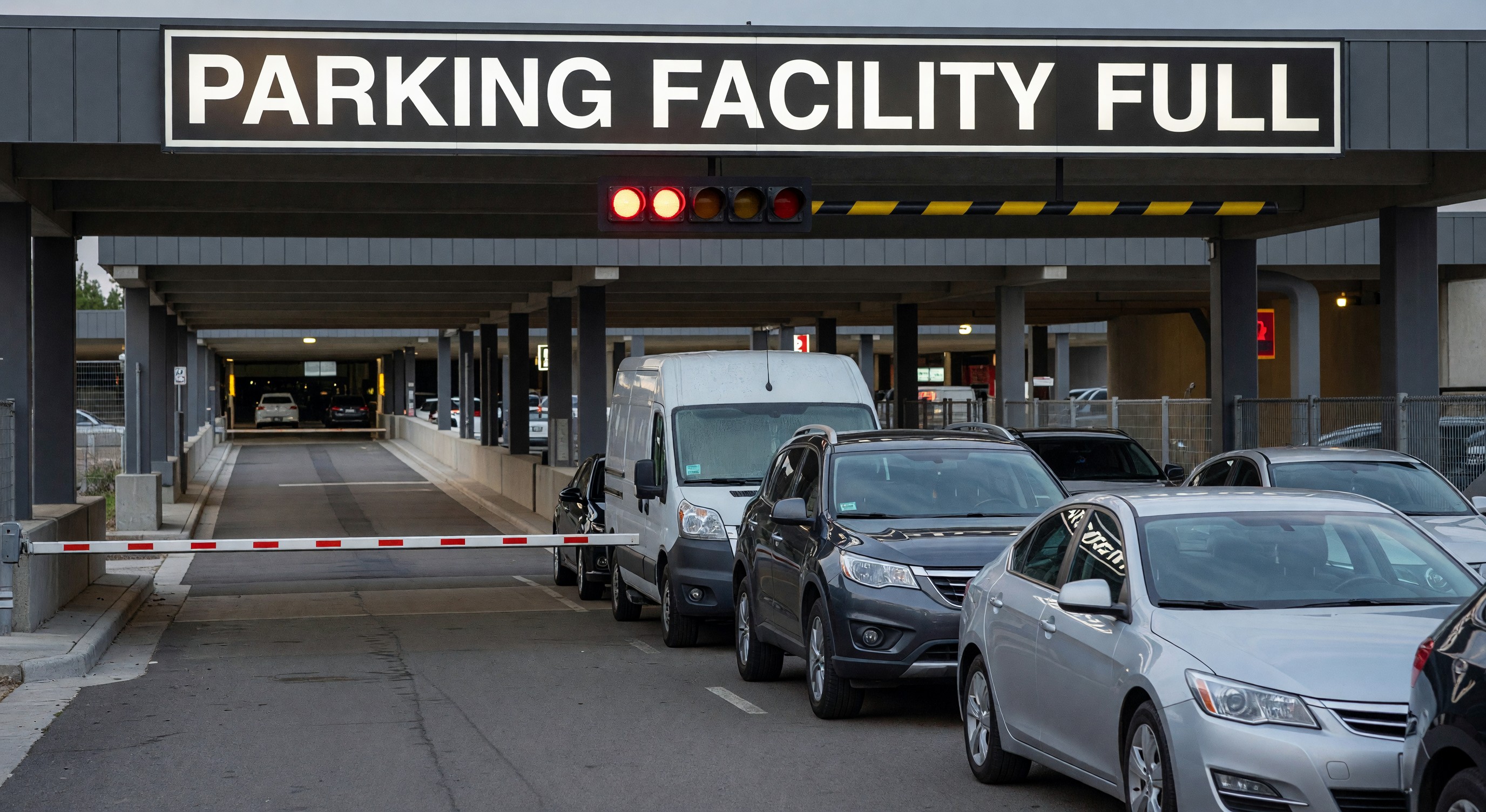 Parking facility entrance with full sign and vehicles waiting to enter